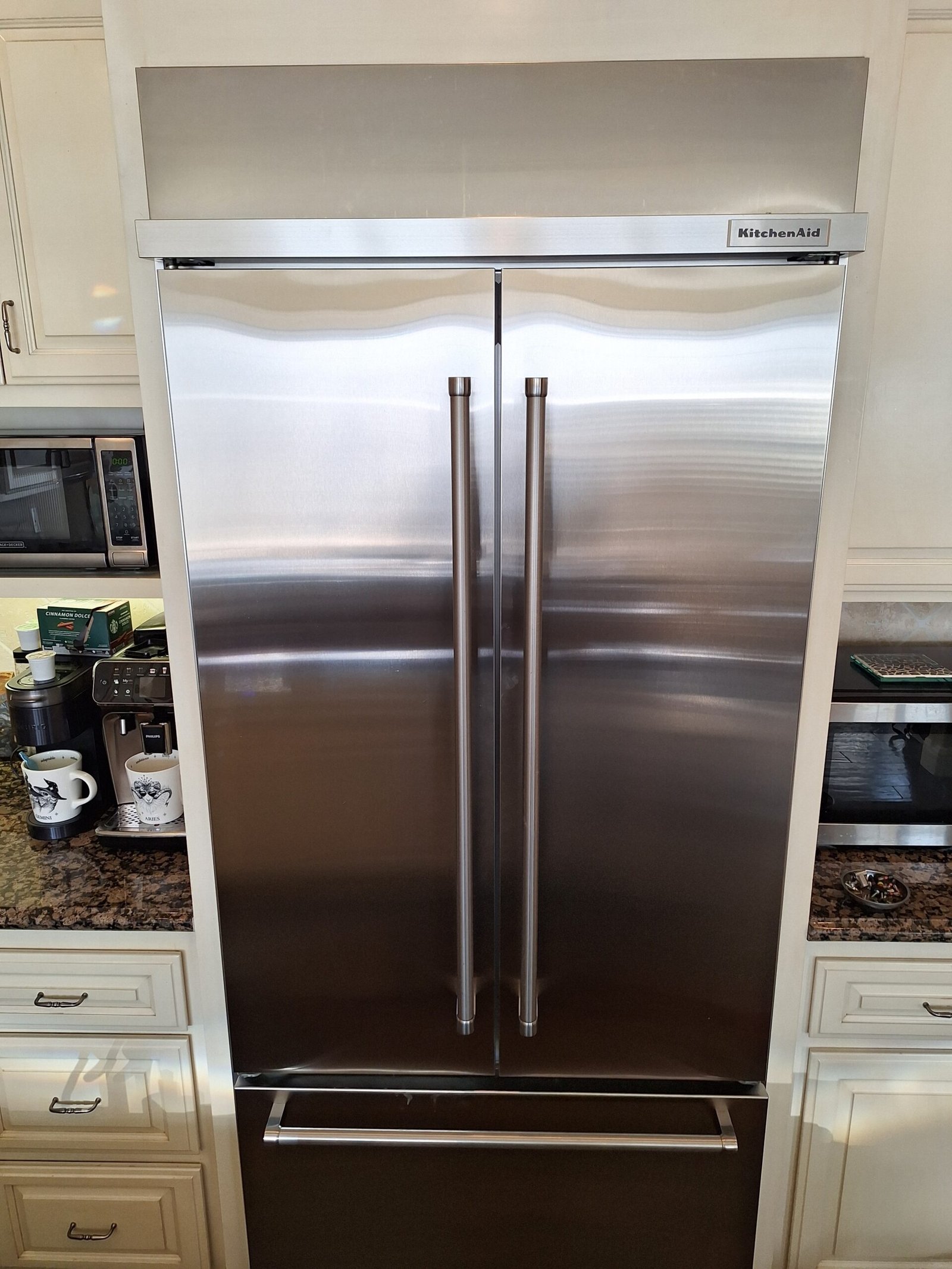 Stainless steel KitchenAid built-in refrigerator with French doors and a bottom freezer drawer